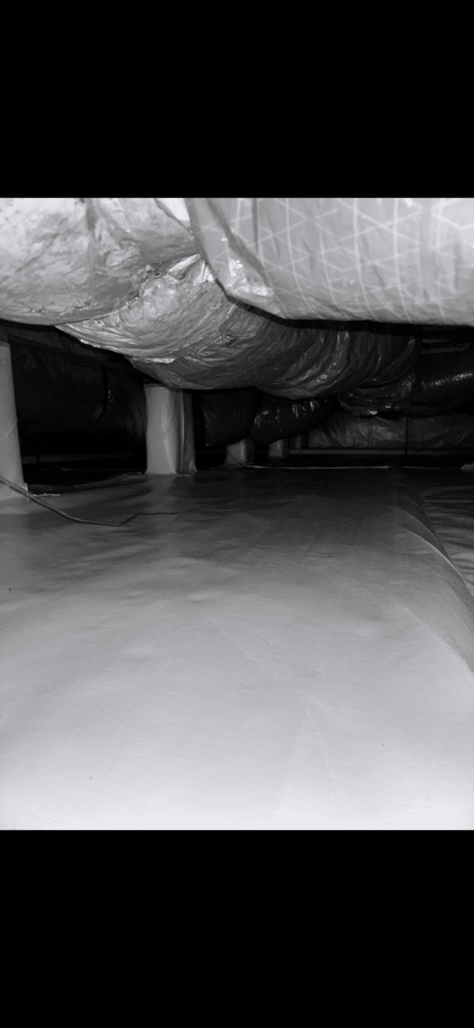 A plastic-lined crawl space with exposed ductwork and support columns visible under a building.