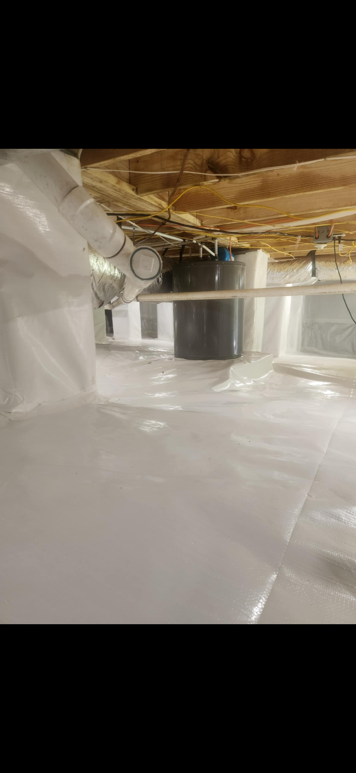 A clean, encapsulated crawl space with a sump pump system and sealed vapor barrier on the floor and walls.